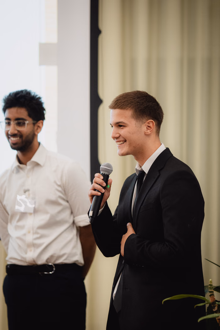 Two finalists smiling during their pitch.