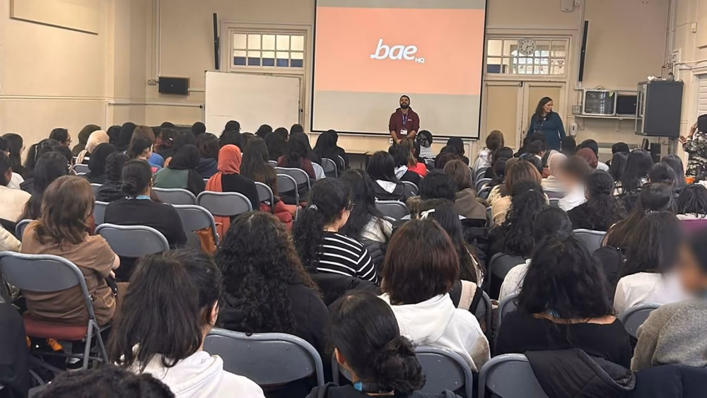 A school hall of sixth formers watching a Youth Startups assembly.