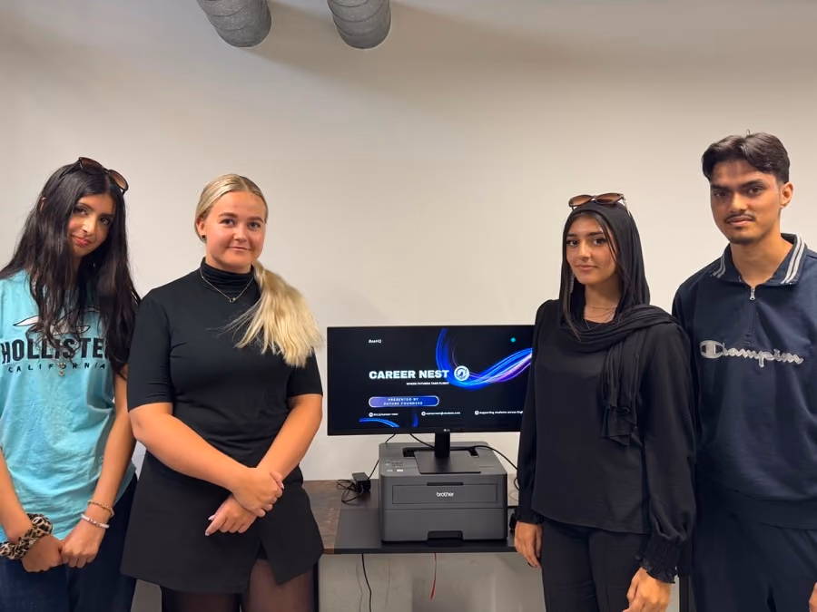 A team beside the screen showing the careers product they built.