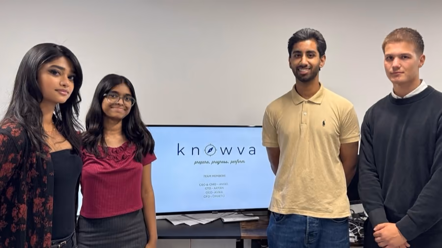 A team beside the screen showing the revision product they built.