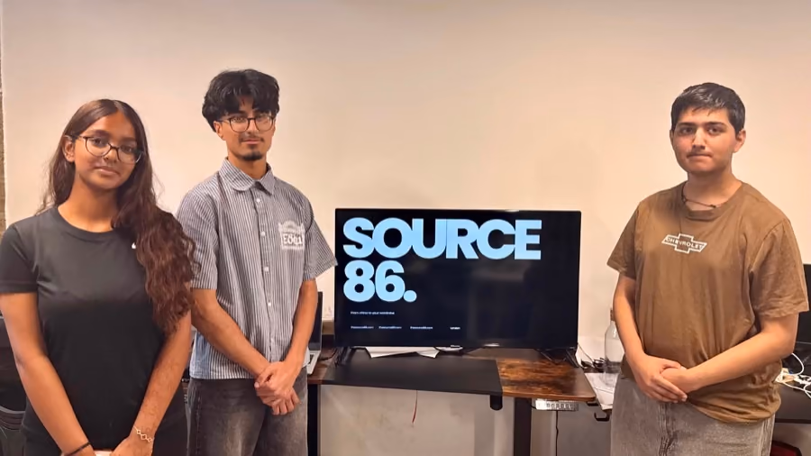 A team beside the screen showing the retail product they built.