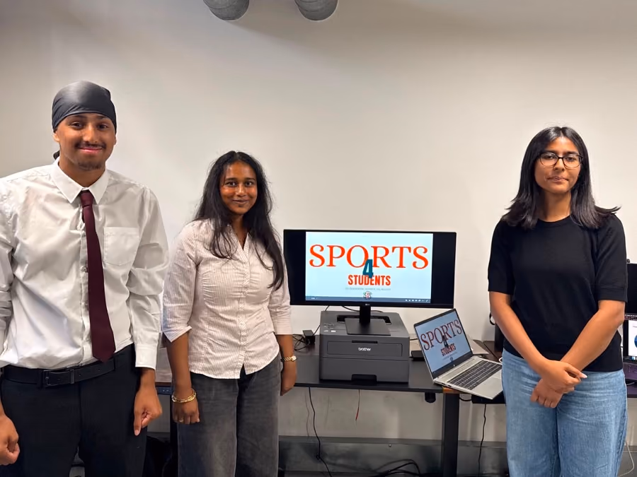 A team beside the screen showing the sports app they built.