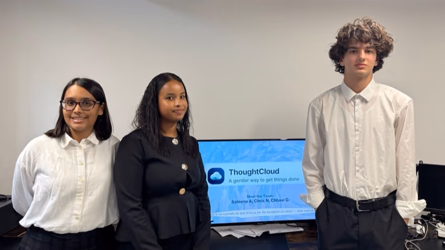 A team beside the screen showing the productivity app they built.